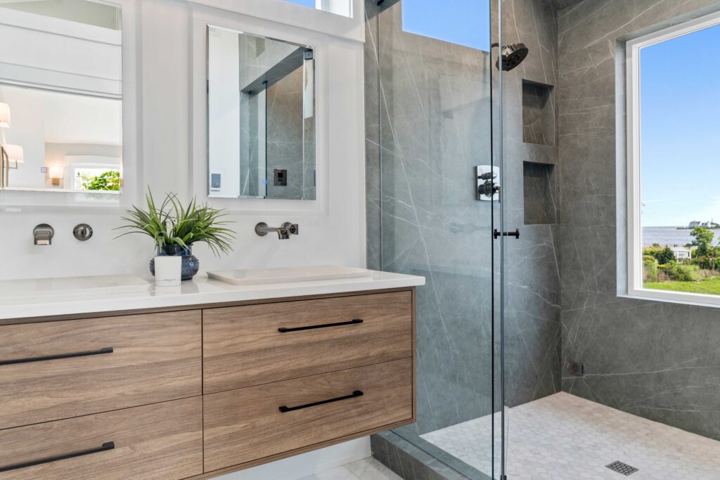 wood vanity glass shower with stone walls
