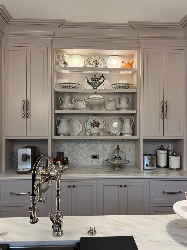 Chrome kitchen faucet, gray kitchen cabinets, marble countertops, china display, taupe kitchen cabinets,