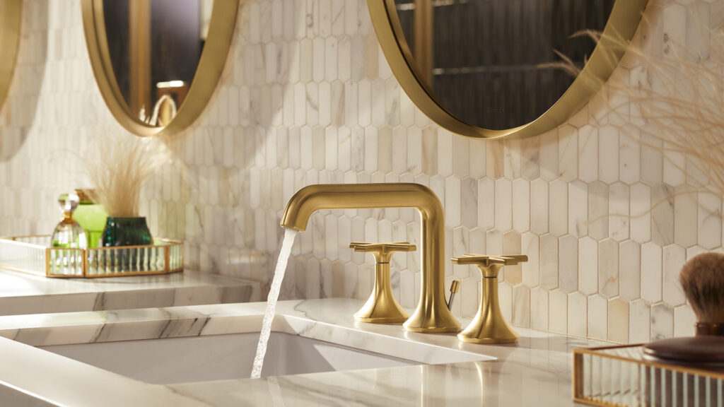gold bathroom faucet with white tile and gold fixtures
