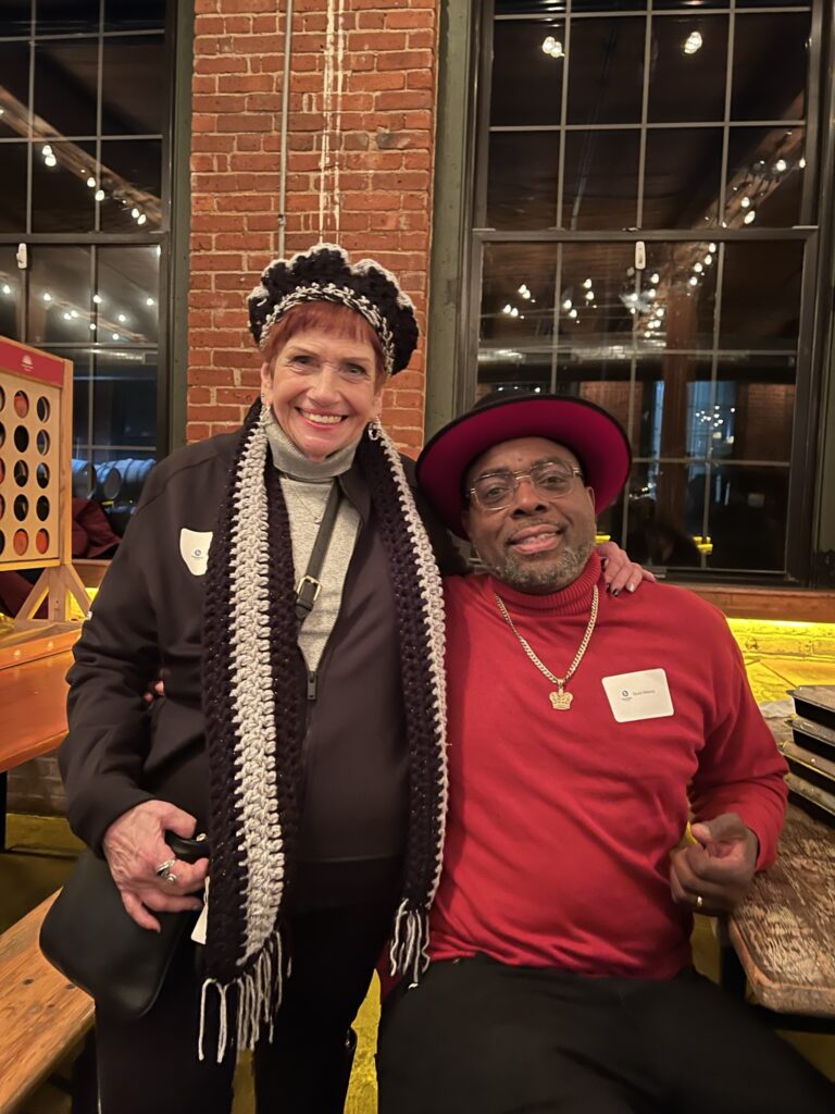 man posing with women at holiday party