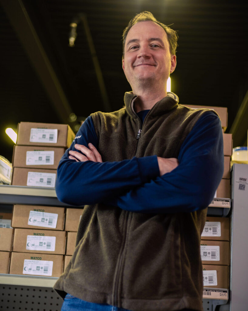 man posing with product behind him